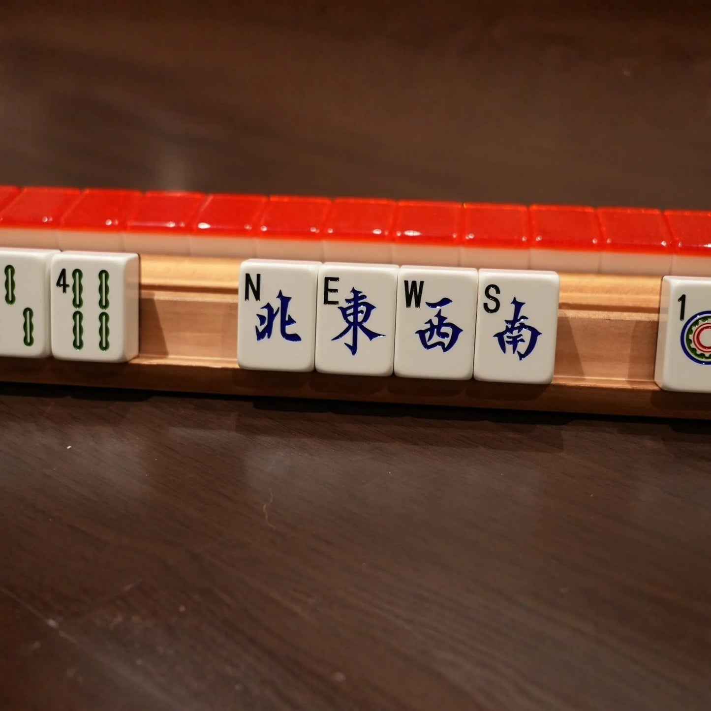 Close-up of a麻将 (mahjong) tile set with tiles displaying numbers and directions.