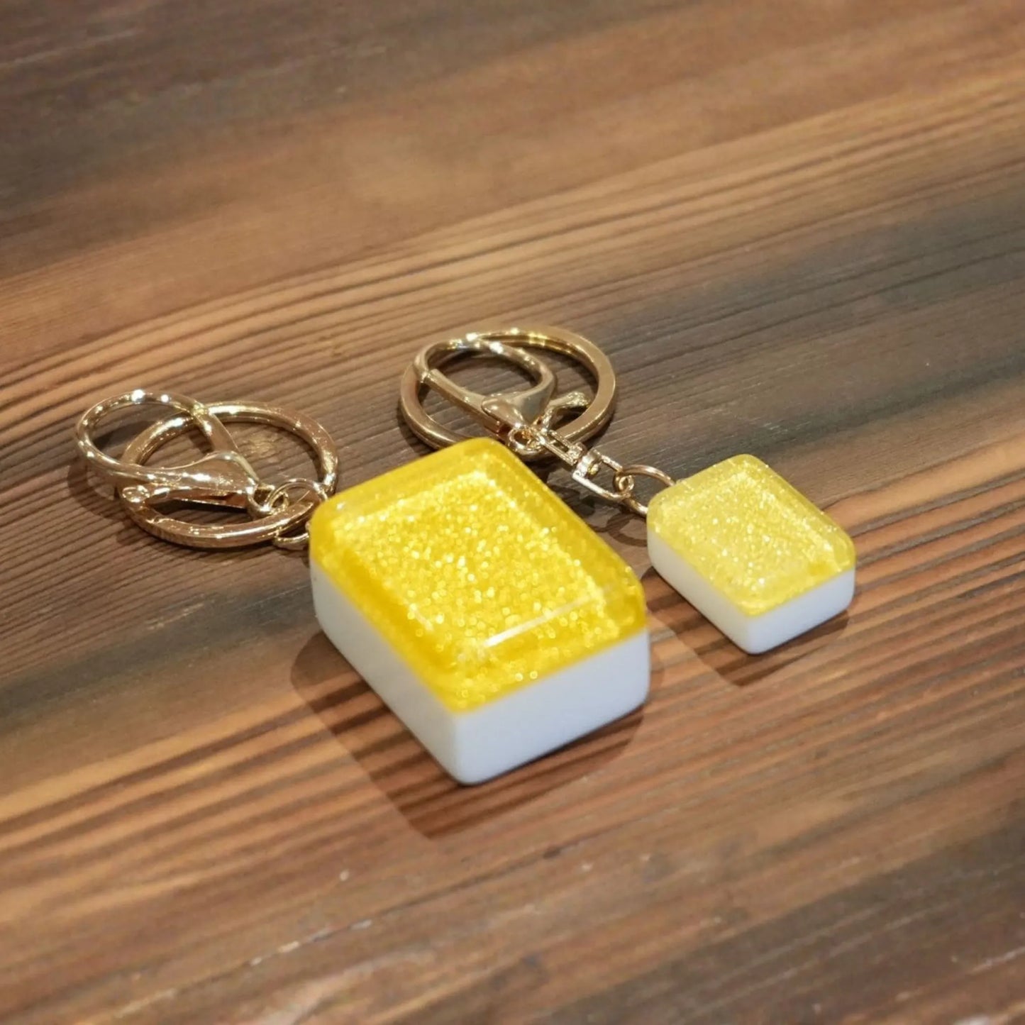 Pair of earrings with yellow and white rectangular stones on a wooden surface