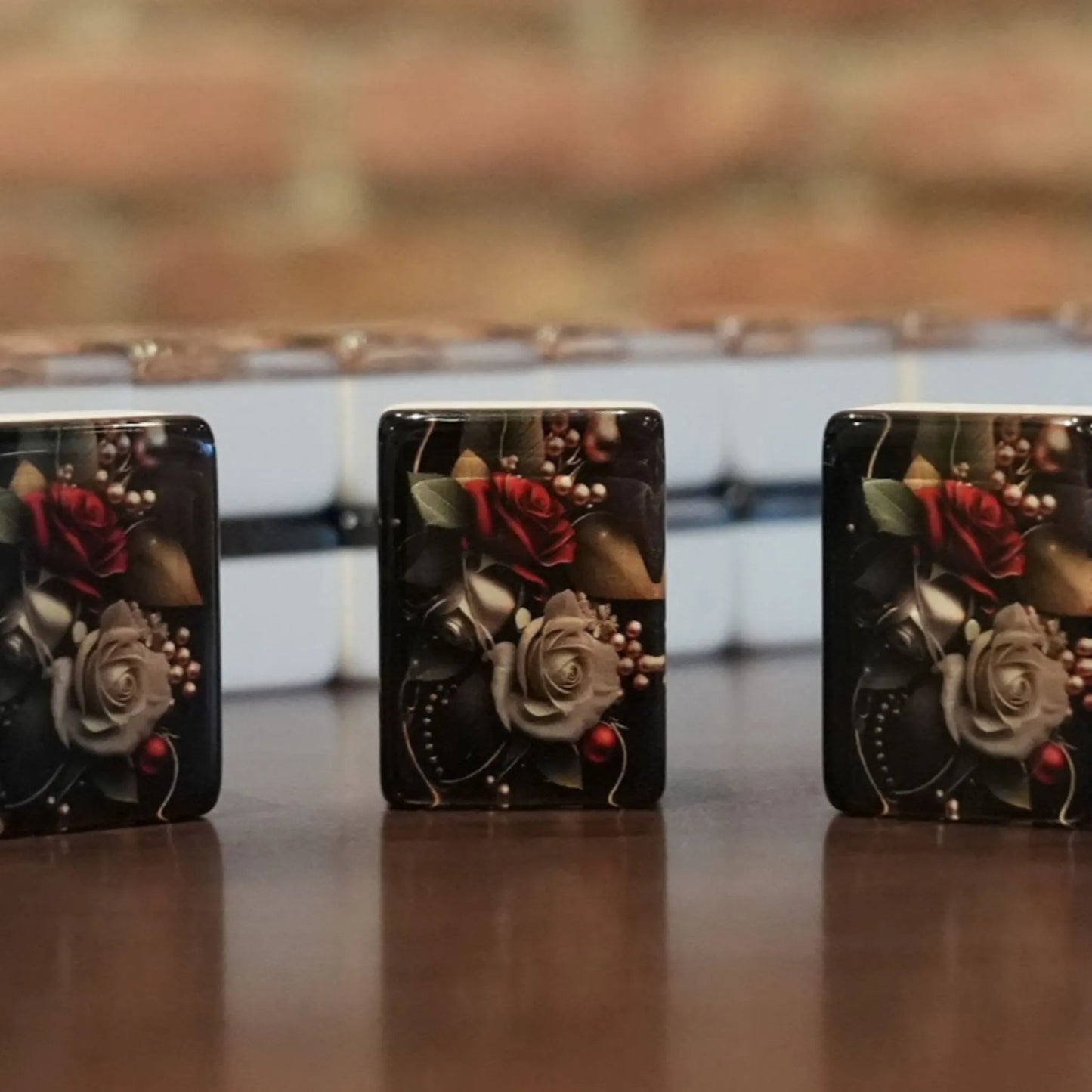 Three standing rose pattern mah jongg tiles displayed on a wooden table with a full wall of tiles in the background.