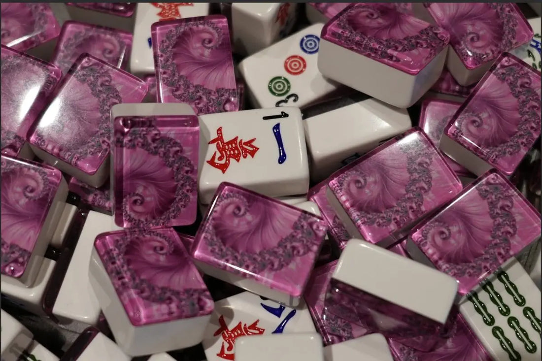 Mixed pile of premium pink swirl mah jongg tiles showing glossy acrylic finish and engraved faces.