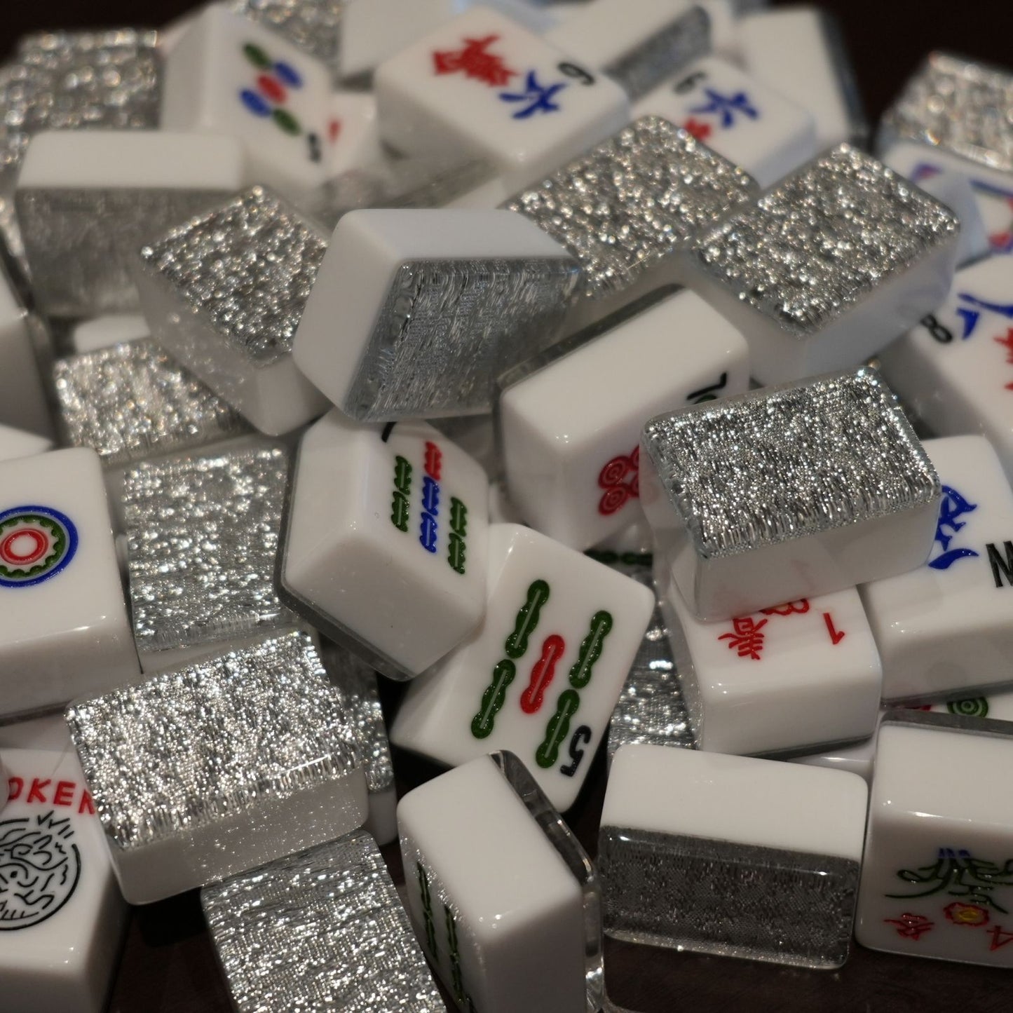 Close-up of a pile of white Mahjong tiles with silver glittery accents.