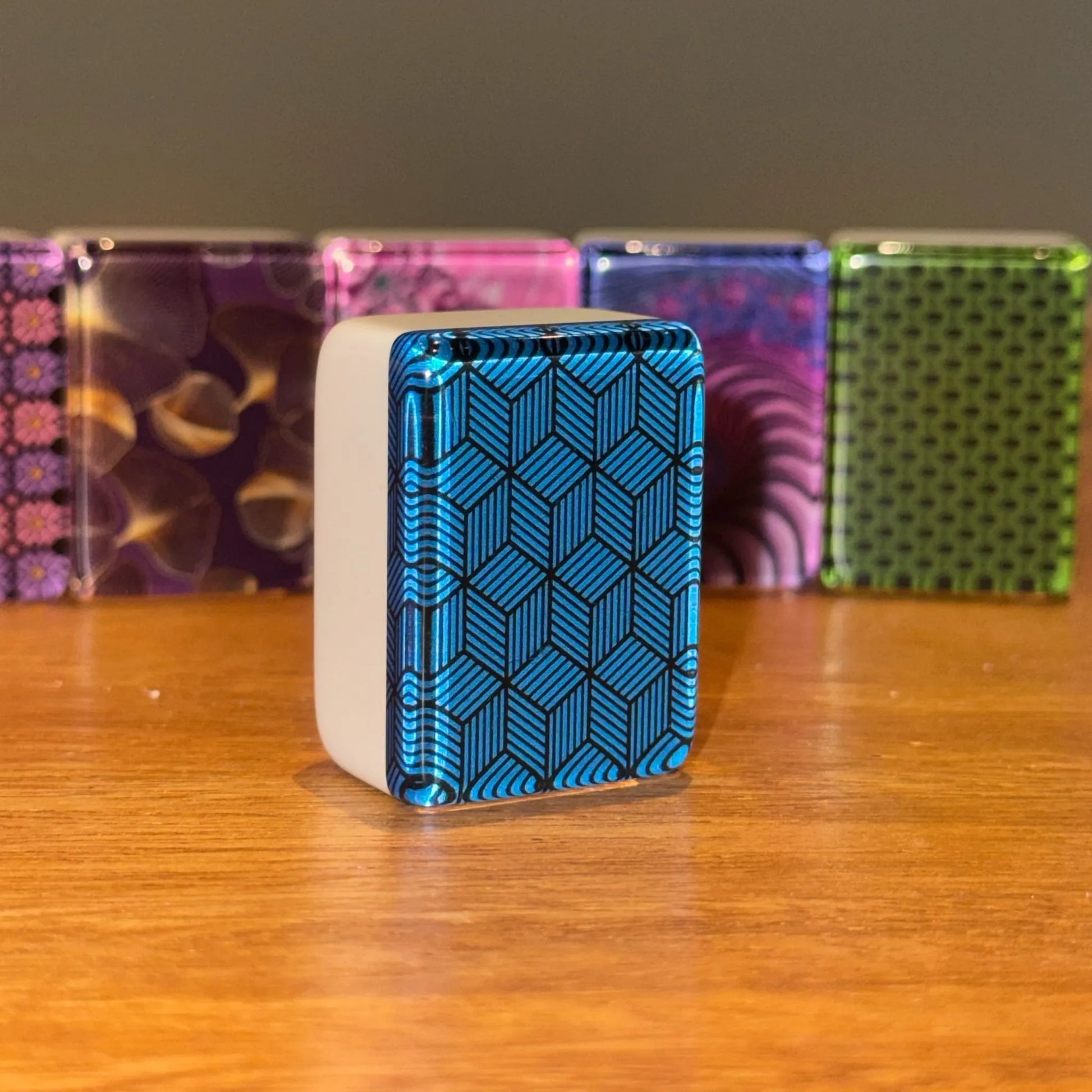 Close up view of a single blue deco weave mah jongg tile standing upright to show the geometric back pattern.