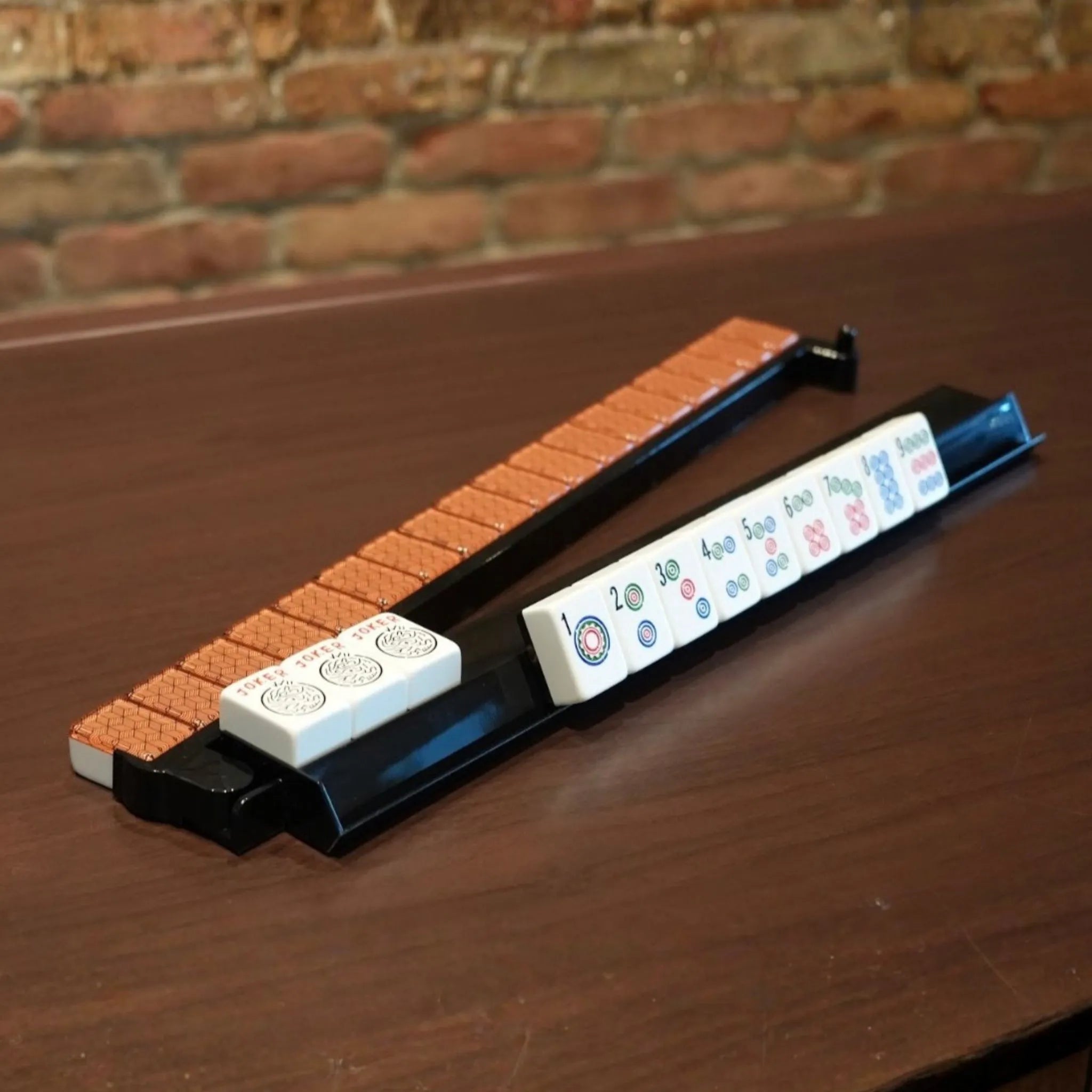 Black acrylic Mah Jongg rack with white tiles on game table