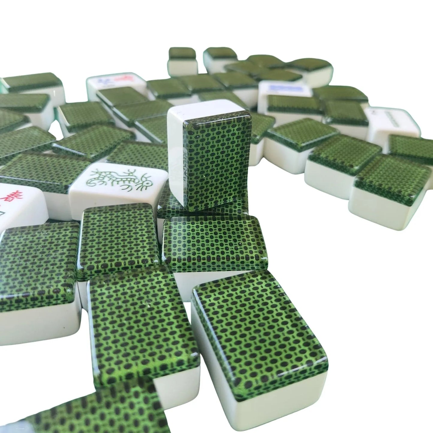 A pile of green and white mahjong tiles on a plain white background, with several tiles standing upright in the center.