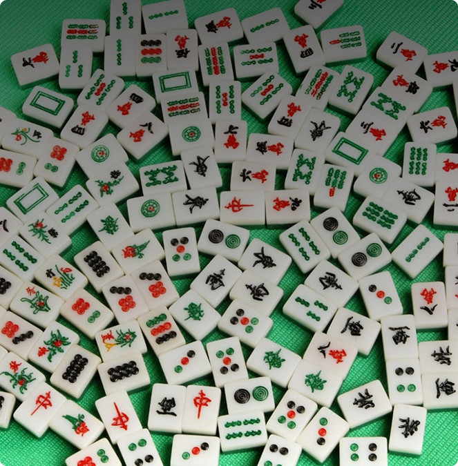 Collection of Mahjong tiles on a green surface