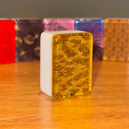 Single gold sparkle 36mm automatic mahjong tile with glitter face on wooden surface
