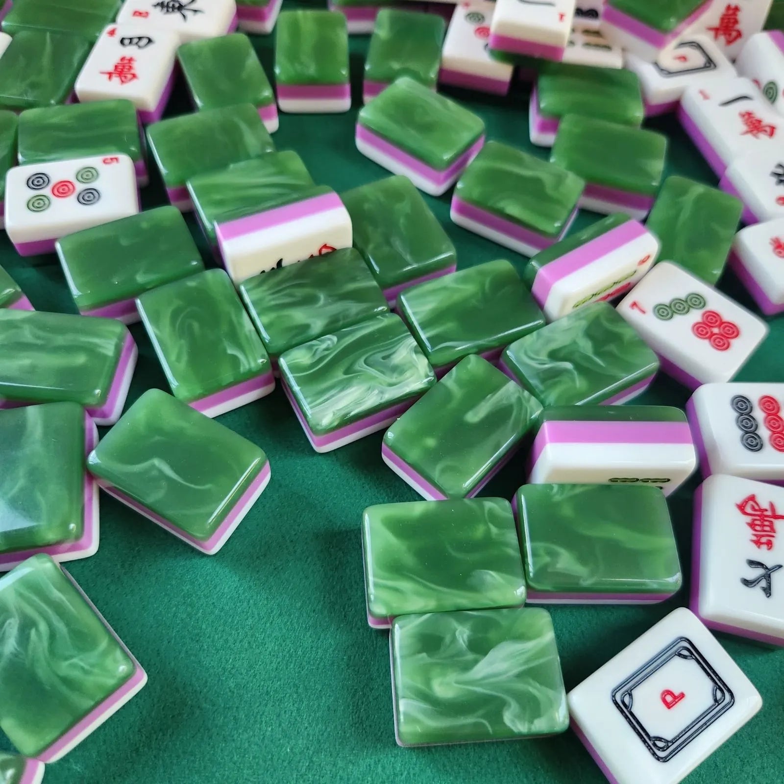 American Mah Jongg tiles with green backs and white faces spread across a game table