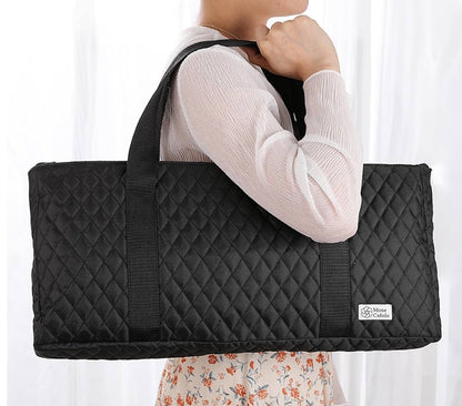 Person holding a black quilted bag with a visible brand logo against a white background