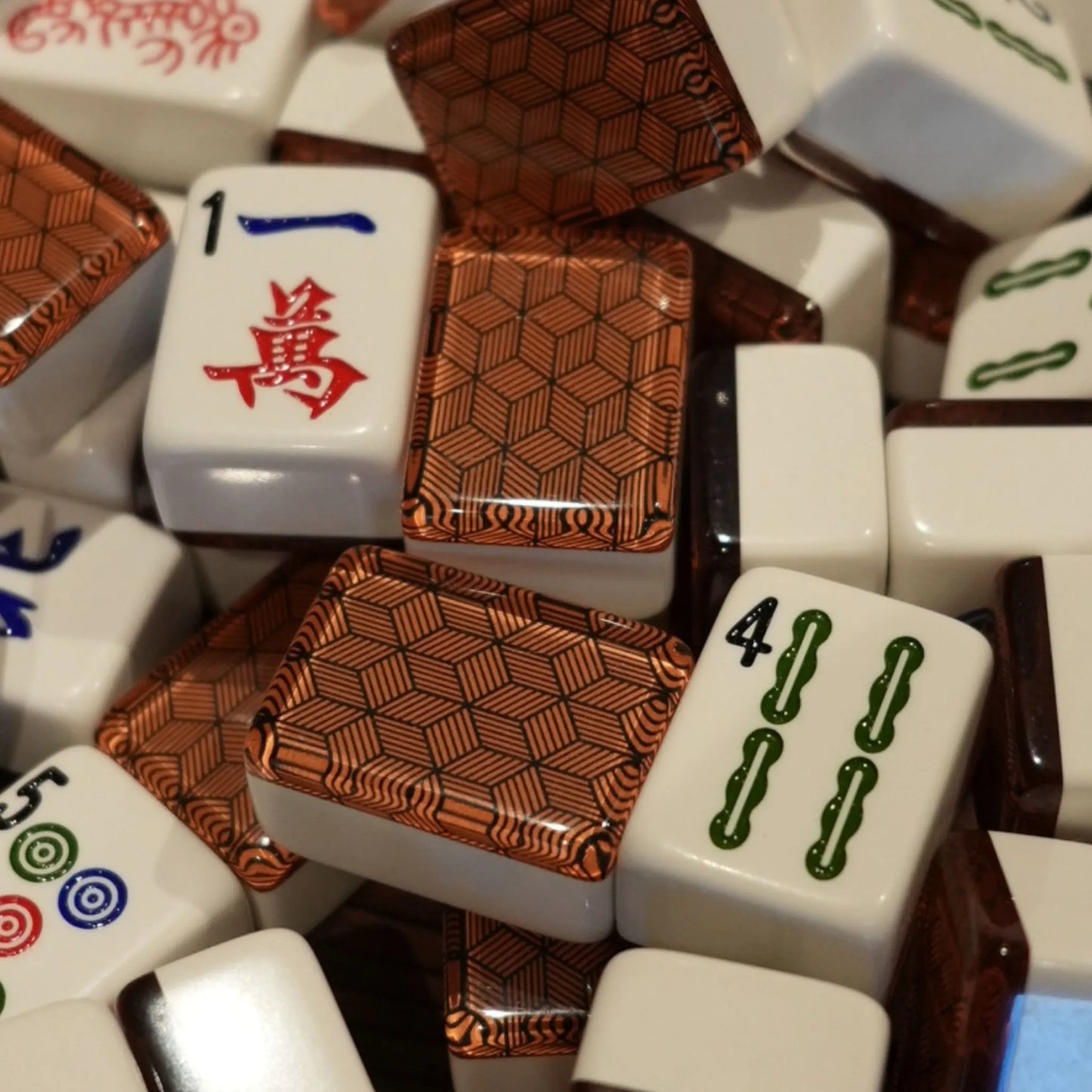 Close-up of metropolitan copper 36mm automatic mahjong tiles showing geometric patterned faces and traditional symbols
