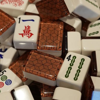 Close-up of metropolitan copper 36mm automatic mahjong tiles showing geometric patterned faces and traditional symbols
