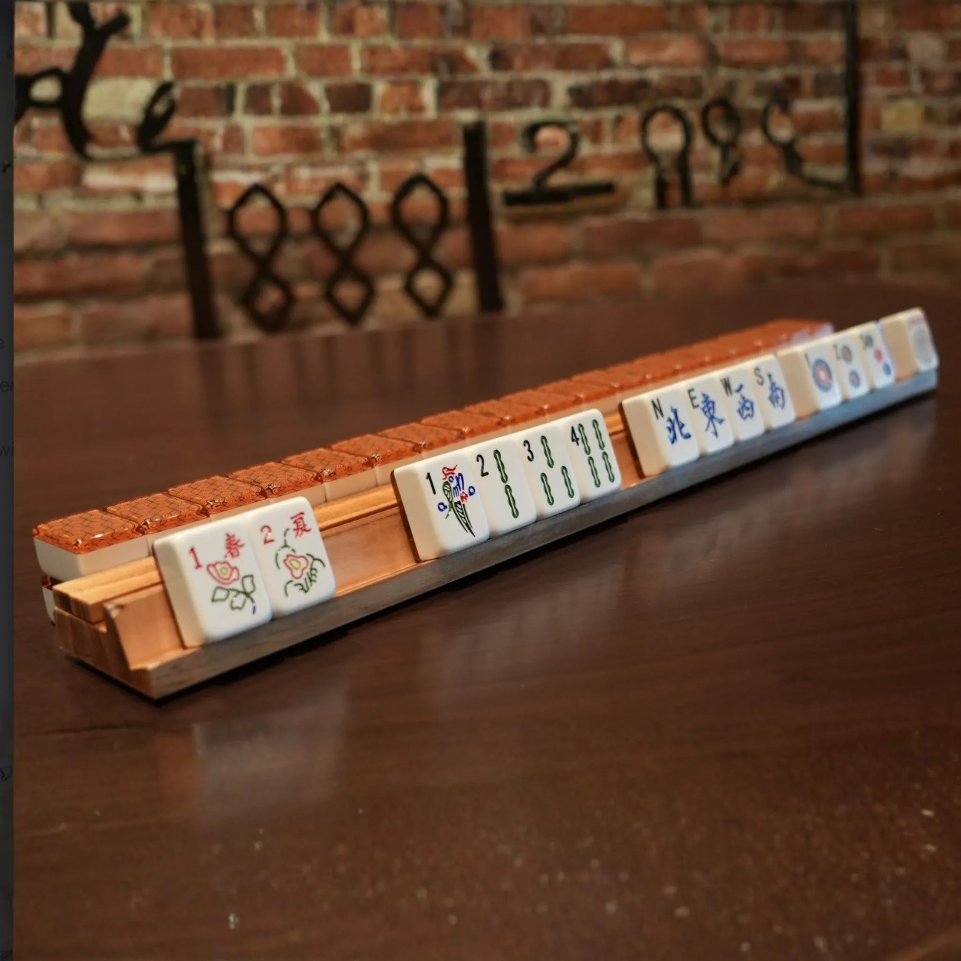 Metropolitan copper 36mm automatic mahjong tiles arranged on a wooden rack
