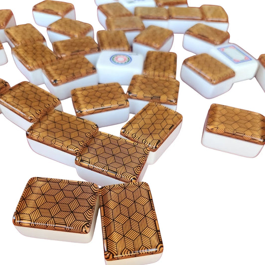 A pile of Mahjong tiles with a glossy white base and textured, geometric wood-grain patterned tops, arranged on a plain white background.