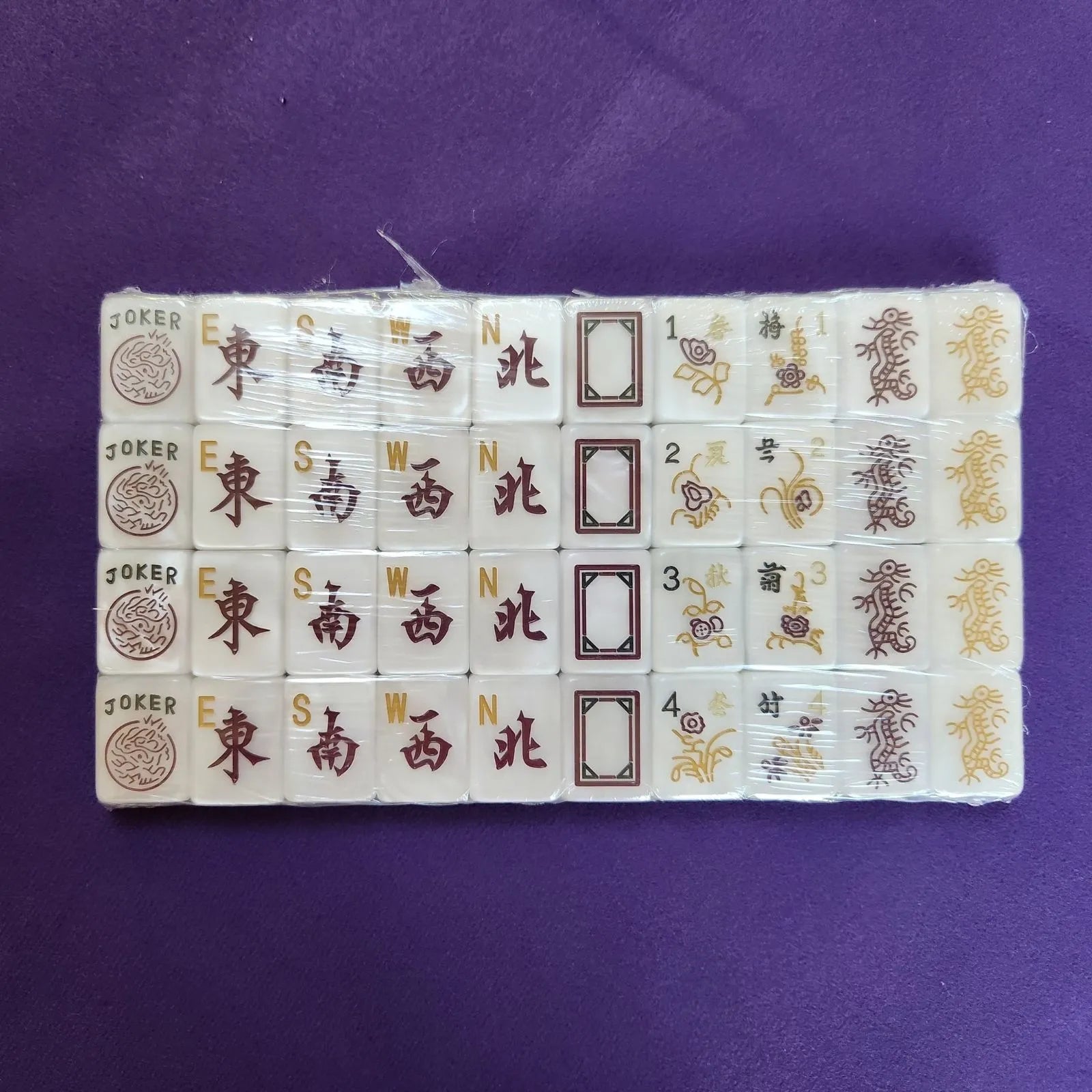 A set of Chinese mahjong tiles arranged in a row on a solid purple background.