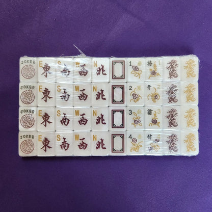 A set of Chinese mahjong tiles arranged in a row on a solid purple background.