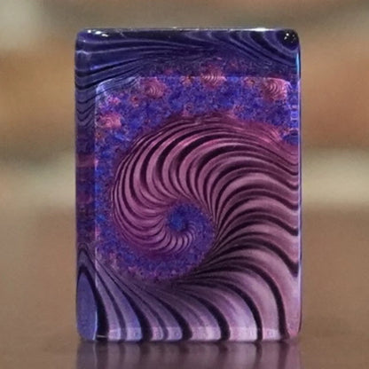 Close up macro shot of a single purple swirl mah jongg tile showing the intricate spiral design on the back.