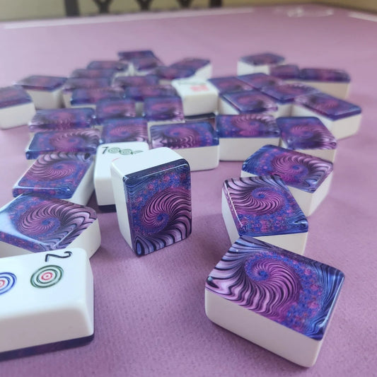 A group of white square game tiles with colorful spiral-patterned tops arranged on a pink surface.