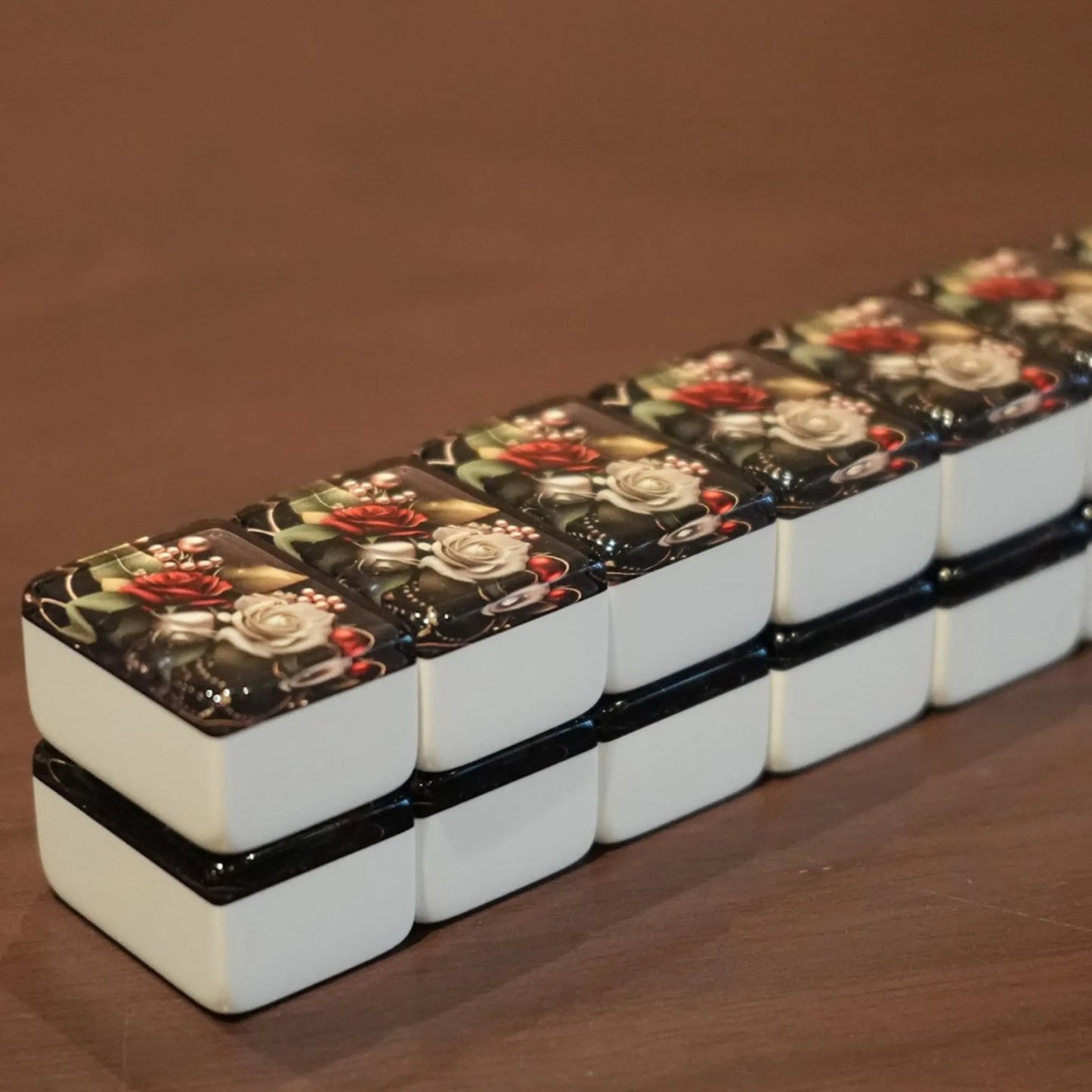 Angled view of a full double-stacked wall of 36mm rose automatic mah jongg tiles ready for play on a wooden table.