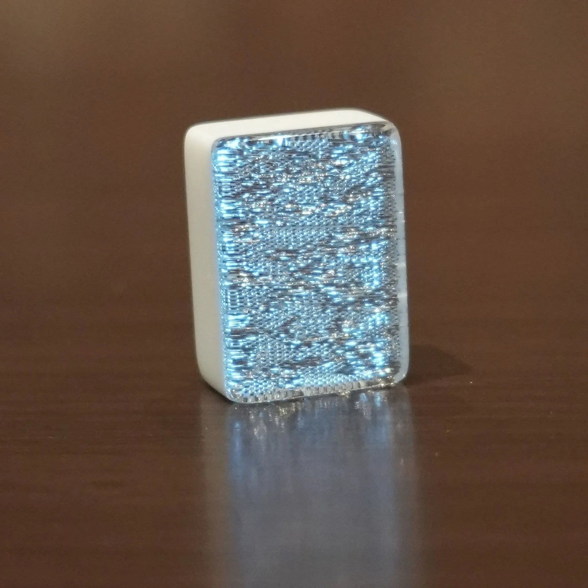 Single silver sparkle 36mm automatic mahjong tile with glitter face on wooden surface
