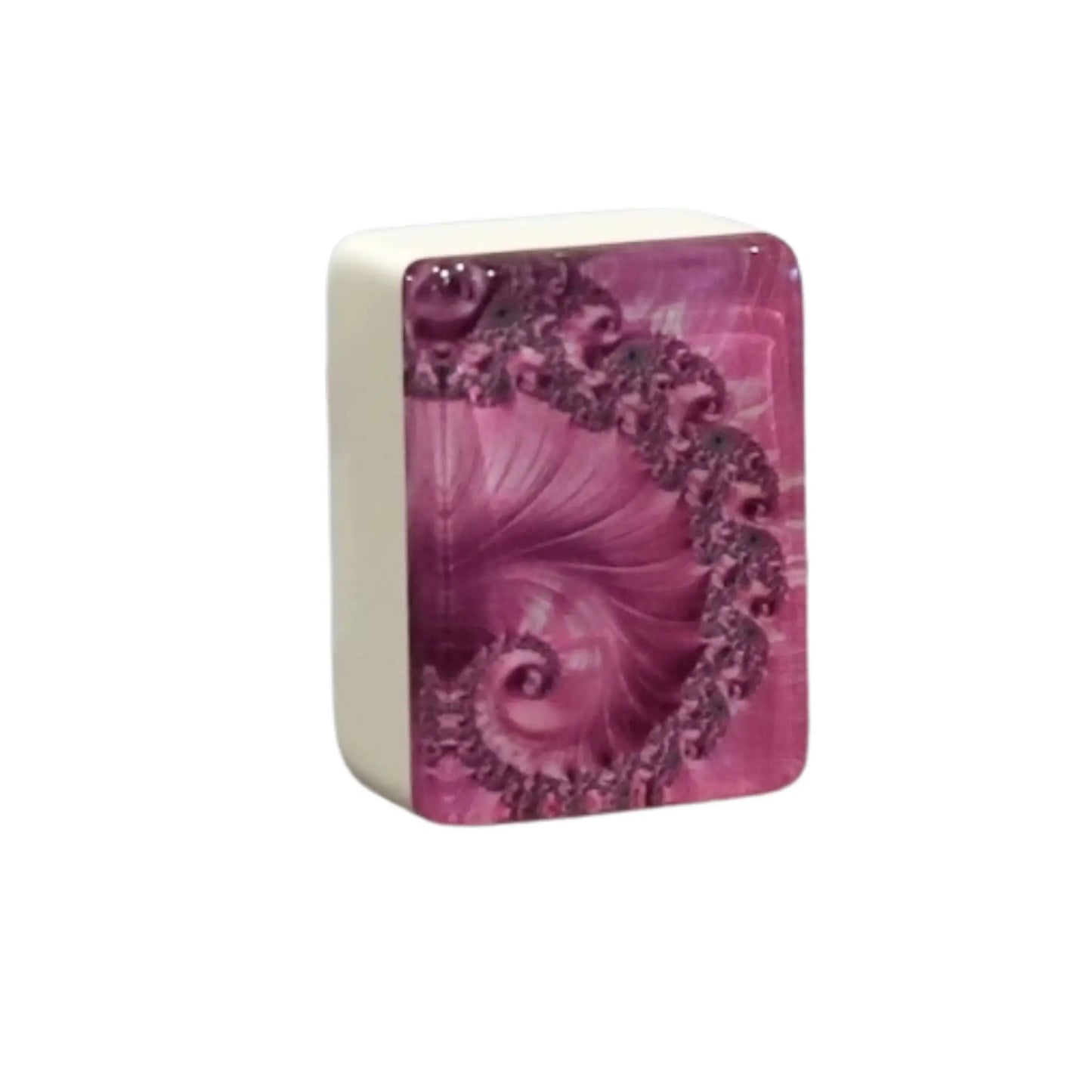 Close up view of a single pink swirl mah jongg tile standing upright to show the intricate spiral back pattern.