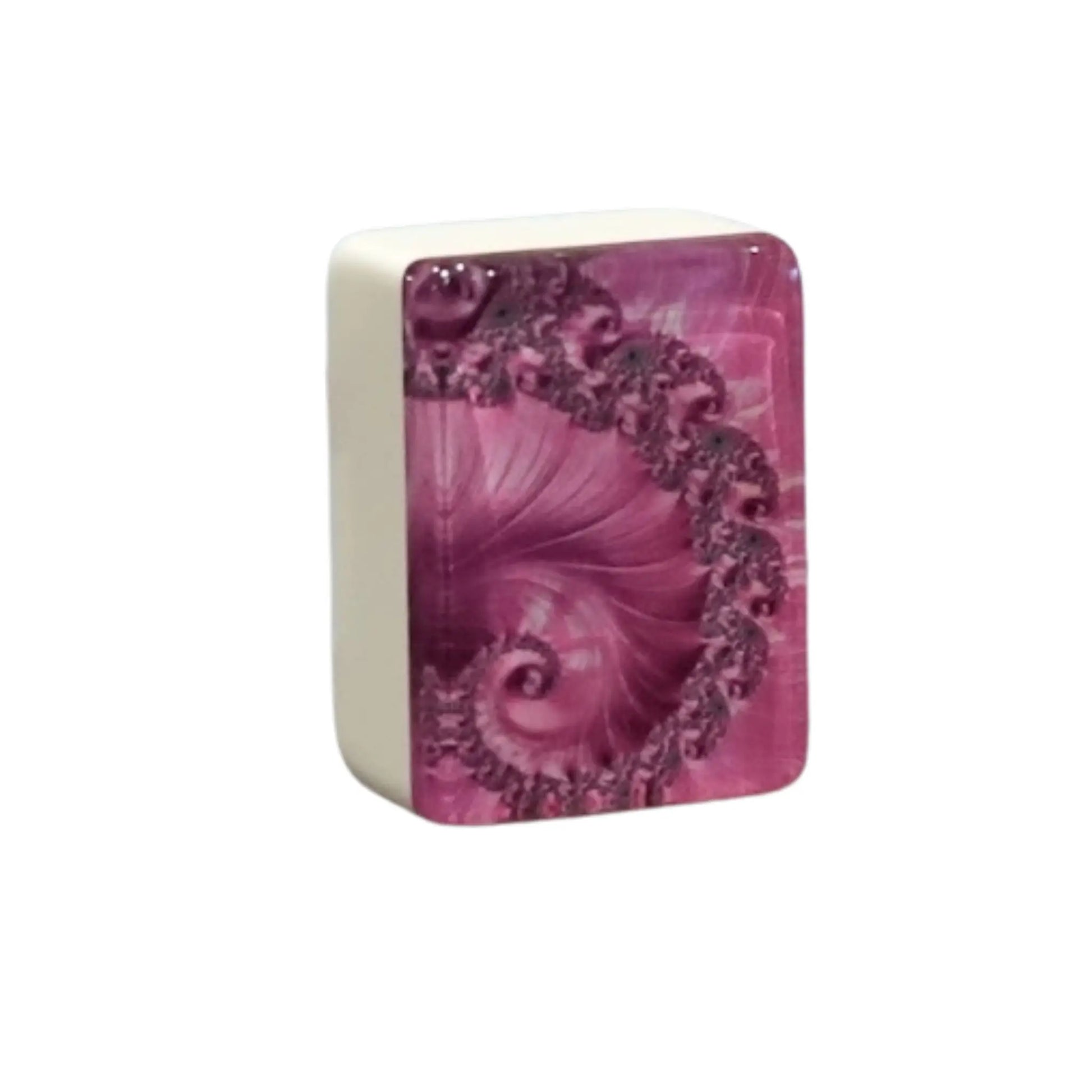 Close up view of a single pink swirl mah jongg tile standing upright to show the intricate spiral back pattern.