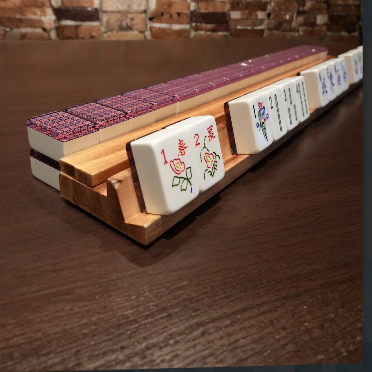 Violet mosaic 36mm automatic mahjong tiles arranged on a wooden rack during gameplay
