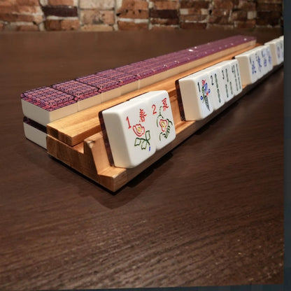Violet mosaic 36mm automatic mahjong tiles arranged on a wooden rack during gameplay
