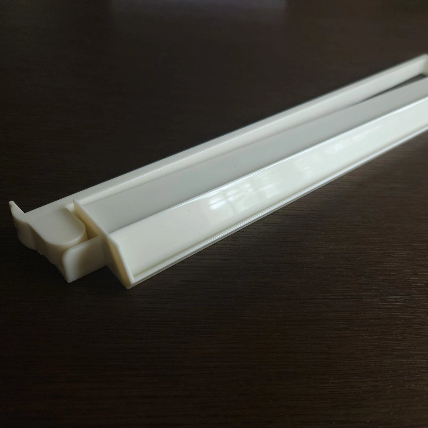 White plastic strip on a dark surface